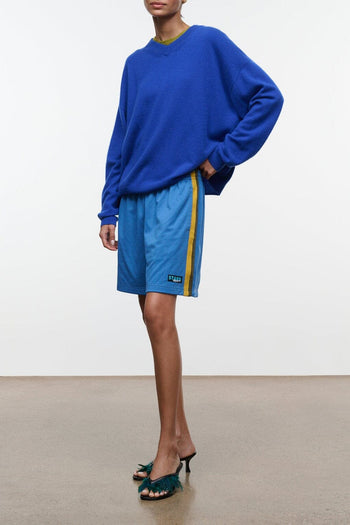 Blue drawstring shorts with side logo patch, above-knee length