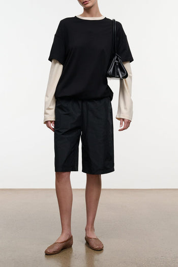 Black bermuda shorts with mid-thigh length and relaxed fit
