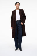 Black ankle sock boots worn with a long dark coat and jeans.