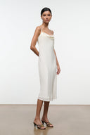 Two-tone mule sandals with crisscross straps and low heel worn with a white dress