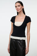 Black scoop-neck knit top with ivory peplum-like ruffle trim