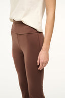 Dark brown slim pants with front yoke seam and low-rise waistband
