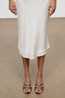 Mule sandals with crisscross straps and low heels worn with a light midi dress