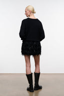 Black feather-fringe mini skirt, back view with straight silhouette