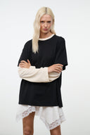 Black oversized tee with short sleeves and ecru long sleeves; straight hemline