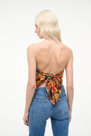 Back view: silk scarf top with colorful travel print and tied bow detail, blue jeans