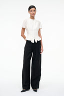 Ivory short-sleeve peplum top with center zipper and flared back hem