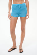 Women’s turquoise swim shorts with drawstring waist, close-up front view