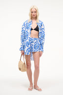 White paddle shorts with blue graphic print, elastic waistband, worn front view