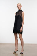 Black sleeveless mini dress 3/4 view with sheer panels and feather fringe