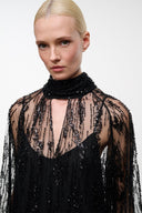 Black sequin mini dress with sheer long sleeves and high ruffled neck