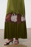 Olive green silk slip dress with brown and white lace panel at the hem