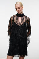 Black sequin mini dress with sheer sleeves and high ruffled collar
