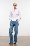 White collared button-up top with long sleeves and hip-length hem