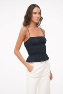 Black smocked peplum cami top with thin straps, side view