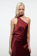 Wine satin halter dress with draped one-shoulder neckline, sleeveless, bias silhouette.