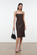 Black mini fringe handbag with thin shoulder strap, worn at side.