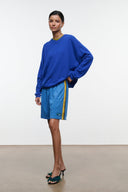Haskell blue shorts with elastic waist and yellow side stripe; side logo patch.