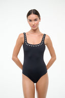 Black one-piece swimsuit with silver eyelet-trim scoop neckline and narrow straps