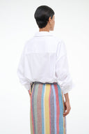 White long-sleeve collared shirt with button-back detail