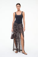 Black one-piece swimsuit worn with a long patterned skirt; silver eyelet neckline trim