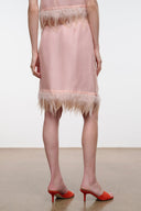 Light pink satin skirt with feather fringe hem, sleeveless top pairing visible