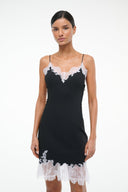 Black mini dress with white lace trim, V-neckline, fitted bodice and short hem