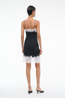 Black mini dress back view with thin straps and white lace trim at the hem