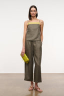 Olive linen cropped pants on model, wide straight cropped silhouette with elastic waist