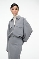 Grey zip-front midi dress with structured shoulders and flap chest pockets