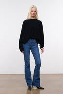 Stone blue denim flare jeans on model, mid-rise with wide-leg straight fit