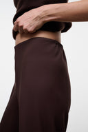 Women's high-rise wide-leg pants, dark brown waistband and smooth drape close-up