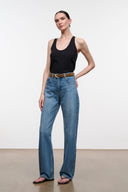 Brown suede belt with silver buckle on blue jeans, styled at the waist.