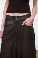Dark brown leather culottes waistband detail with button closure and belt loops.