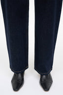 Pair of black ankle sock boots worn with dark denim jeans.