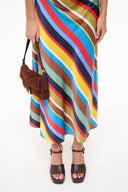 Brown platform heeled sandals with ankle strap, styled with a multicolor striped skirt