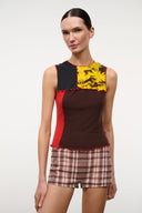 Front view of sleeveless Primo top: yellow floral upper panel, dark brown body, red side stripe