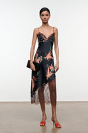 Black silk dress with floral print, lace hem, spaghetti straps, styled with clutch