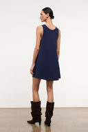 Sleeveless navy dress with U neckline and flared skirt, side view