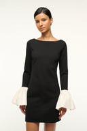 Black long-sleeve mini dress with ivory ruffled cuffs, front view