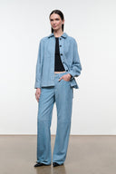 Sky blue suede pants on model, front view with belt loops and wide straight legs.