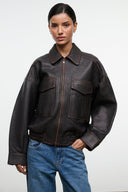 Distressed brown leather jacket with spread collar, zip front, and flap pockets