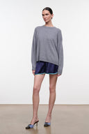 Dark navy sleep shorts with teal waistband and turquoise edge trim, model standing