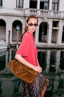 Brown leather messenger bag with braided trim and adjustable crossbody strap