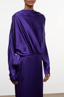 Purple silk dress with draped cowl neckline, flowing long sleeves, and tied waist