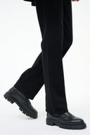 Black ankle boot with chunky lug sole and low-profile side zipper