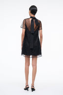 Mini dress back view with neck-tie detail and sheer star-pattern mesh over dark onyx body.