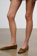 Cigar brown suede flat slip-on loafers on feet, low profile sole