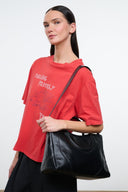 Black glossy satchel bag with top handles and crossbody shoulder strap