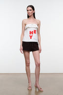 Mule sandal worn with braided cream and red straps and low block heel.